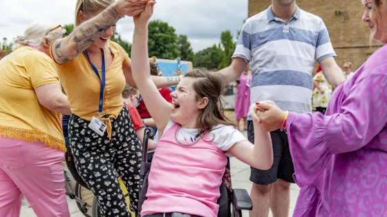 female student laughing in her wheelchair and dancing