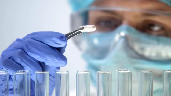 Scientist in goggles scrutinising work