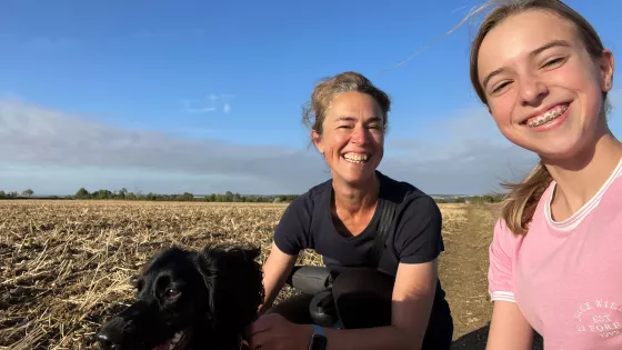 2 women smiling with dog