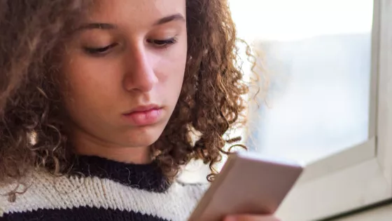 Photograph of a young woman looking at her mobile phone