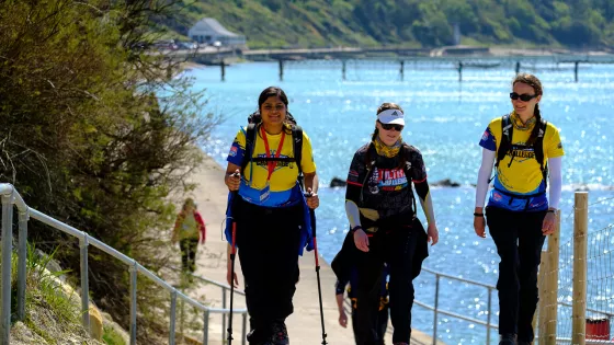 Women walking with sea in background