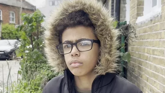 Young boy looks seriously at camera