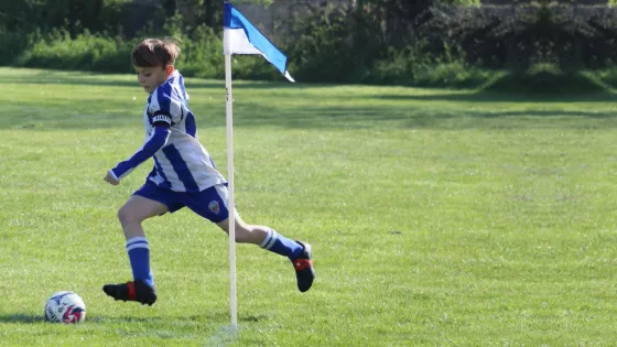 Young boy plays football in a field