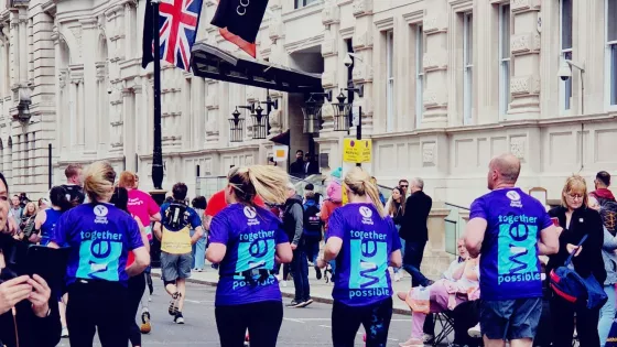 4 runners running away from camera in purple Young Epilepsy Tops
