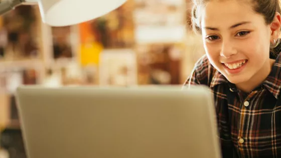 Girl smiling looking at her laptop