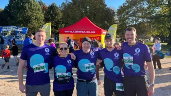 Team of runners smiling in young epilepsy tops