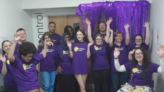 A group of young people with epilepsy cheer while wearing purple t-shirts.