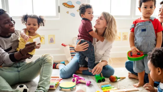 Parents and their infants play with colourful toys in a welcoming space.