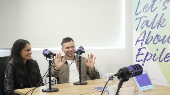 Young girl and F1 broadcaster smiling and chatting on a podcast recording