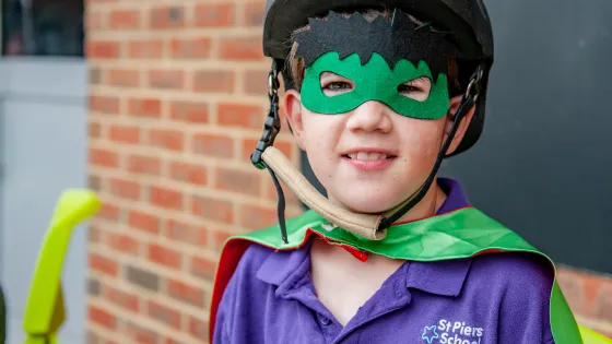 Young boy in St Piers t-shirt dressed as a super hero