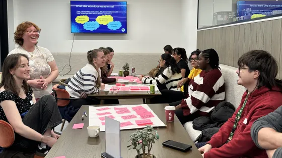 A group of young people discussing content ideas around a table.