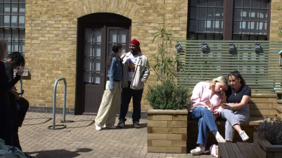 A group of young people socialise in front of a camera person.
