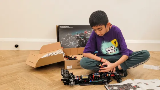 A young man in a Young Epilepsy t-shirt plays with lego.