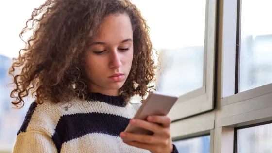 A young girl uses her mobile phone.