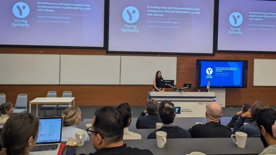 A woman performs a lecture on Young Epilepsy research.
