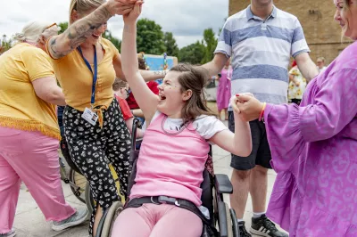 female student laughing in her wheelchair and dancing