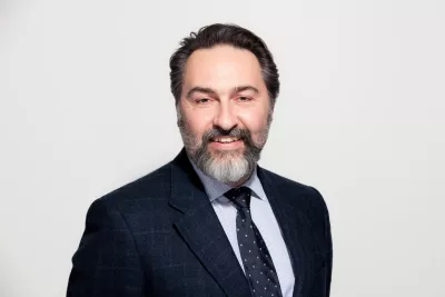 Young Epilepsy CEO Mark Devlin smiles to camera against a white background.