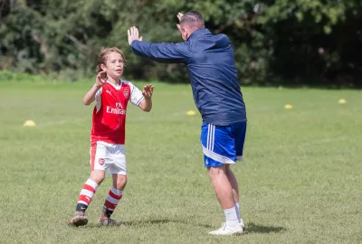 young boy is football training with the coach for Young Epilepsy's partner for Football Experience event, Nicky Barnes Soccer 