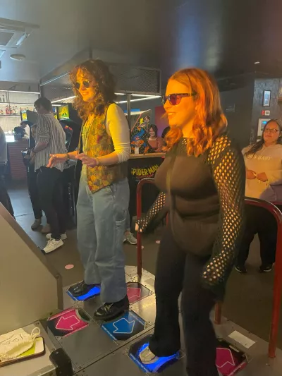 2 young girls playing a dance mat in an arcade