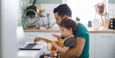 Father on laptop with baby boy sitting on his lap