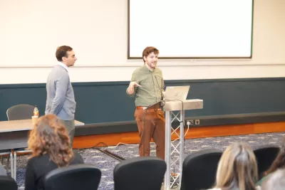 A lecturer speaks at a podium before a research retreat with Young Epilepsy.