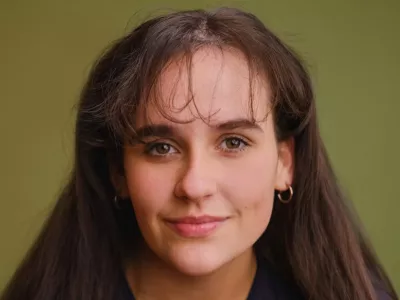 A young woman with a fringe smiles to camera.