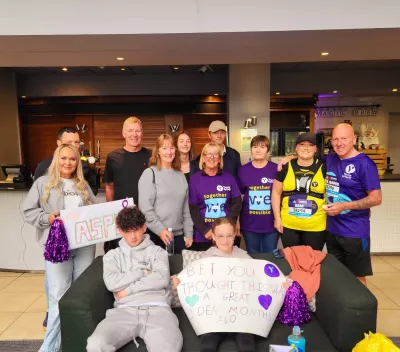 A family shows off their supportive signs for their marathon-running mum and grandfather.
