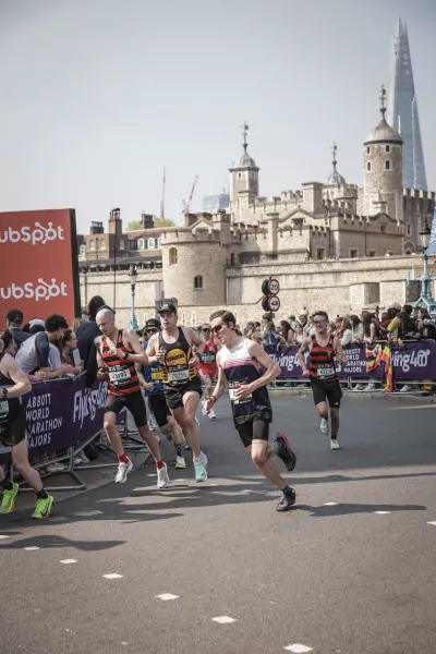 The Tower of London rises behind the London Marathon runners.