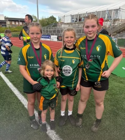 A group of young rugby players pose in their uniforms.