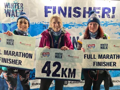 3 women smiling with finishers signs