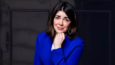Rosie Holt smiles in a deep blue blue jacket.
