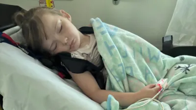 Lily lies sleeping in a hospital bed.