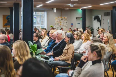 A crowd of women sit watching a Hear Her Voice panel.