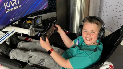 A young boy plays a simulated racing game.