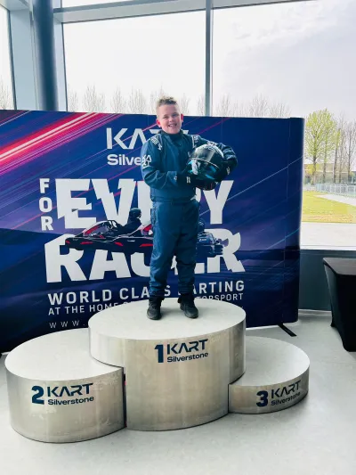 Jamie, a young boy with epilepsy, stands on the first-place podium at CarFest.