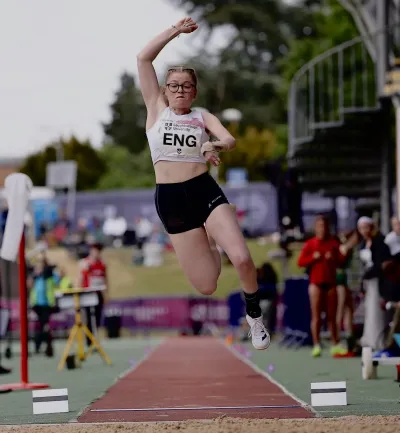 A woman performs a high jump at a sporting event.