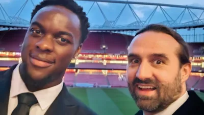 Two young men in suits stand in a stadium at the Empowerment Awards.