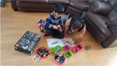 A father and son play with Lego.
