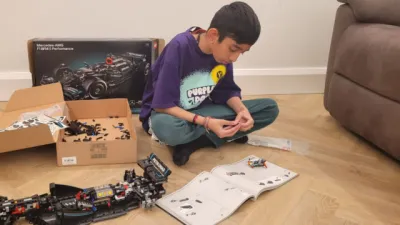 A young boy plays with Lego in a Young Epilepsy t-shirt.