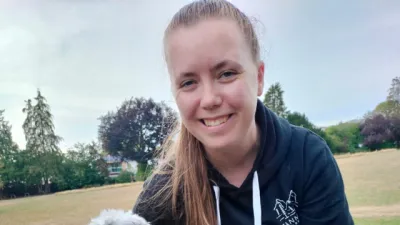 A young woman holds a dog and smiles.