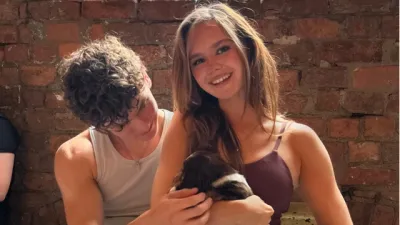 A young couple hold a cute puppy.