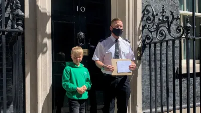 A young boy stands with a politician outside number 10.