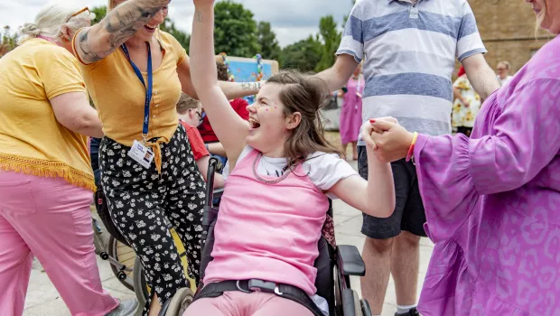 female student laughing in her wheelchair and dancing