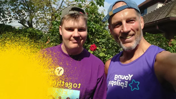 Selfie of older man and younger man, earing Young Epilepsy t-shirts, smiling in the sunshine