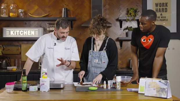 Two men and a woman preparing food