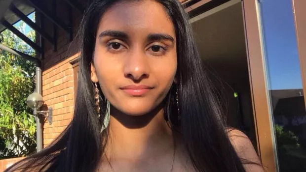 A young woman, Anoushka, looks into the camera for a selfie.