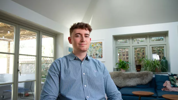 young man sitting smiling at the camera