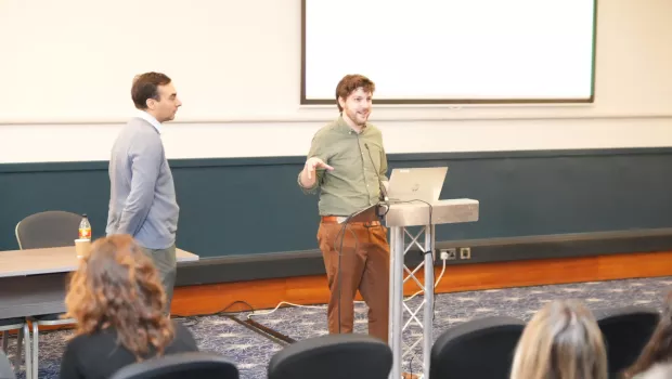 A lecturer speaks at a podium before a research retreat with Young Epilepsy.