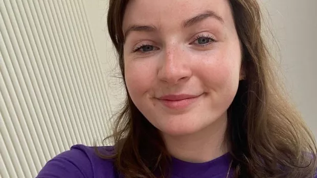 Rachael, a young woman, smiles in a selfie in a Young Epilepsy t-shirt.