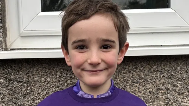 Boy smiling, doing thumbs up in a 26 miles tshirt